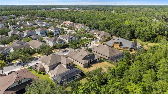 drone / aerial view featuring a residential view and a wooded view