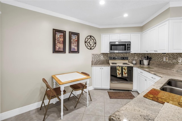 6011 Bahia Del Mar Blvd Unit 158, Saint Petersburg, FL 33715 - kitchen with stainless steel microwave, electric stove, tasteful backsplash, white cabinets, and ornamental molding