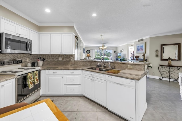6011 Bahia Del Mar Blvd Unit 158, Saint Petersburg, FL 33715 - kitchen with white appliances, a sink, a peninsula, crown molding, and white cabinetry