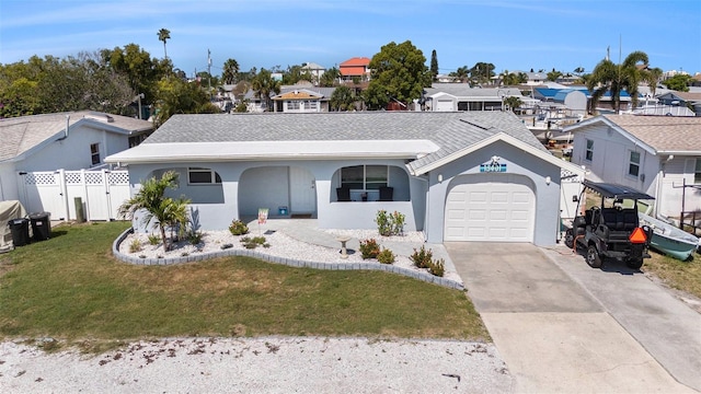 ranch-style home featuring driveway, a residential view, a garage, fence, and a front lawn