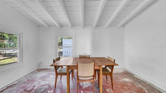 dining space with baseboards, beamed ceiling, concrete floors, and a wealth of natural light