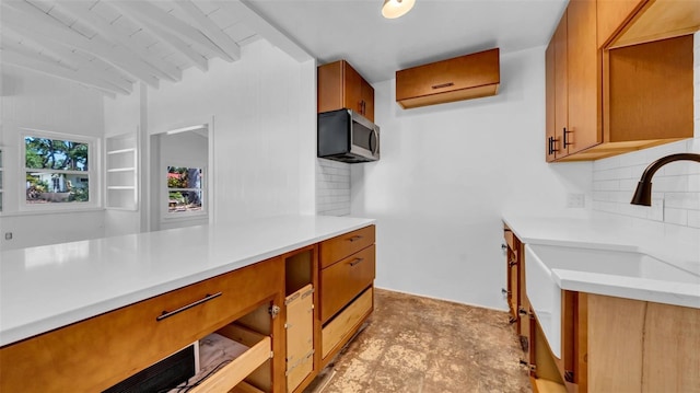 kitchen featuring light countertops, stainless steel microwave, a wall unit AC, and tasteful backsplash