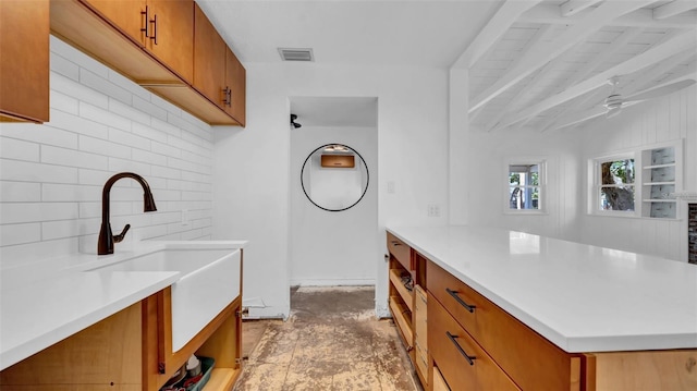 laundry room with a sink, ceiling fan, and visible vents