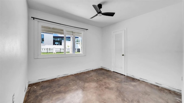spare room featuring ceiling fan and concrete floors
