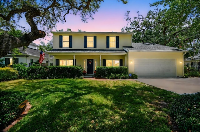 view of front of property with a yard, stucco siding, driveway, and a garage