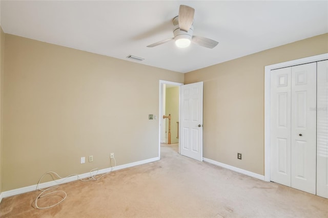 unfurnished bedroom with light colored carpet, a closet, visible vents, and baseboards