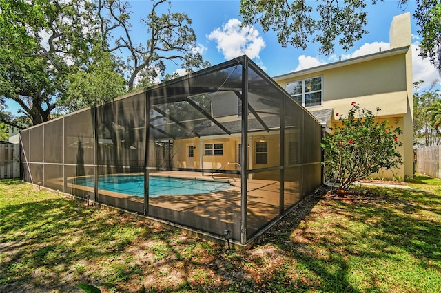 rear view of house with a yard, stucco siding, a fenced in pool, and fence