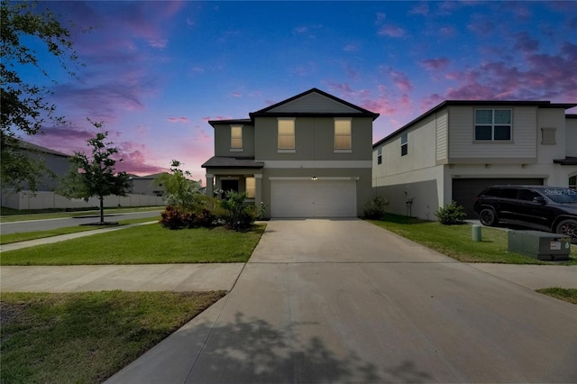 traditional-style home with a garage, stucco siding, driveway, and a front lawn