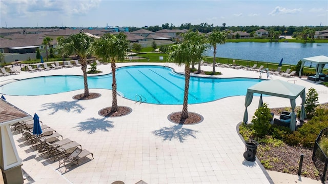 pool featuring a water view, a patio area, and a residential view