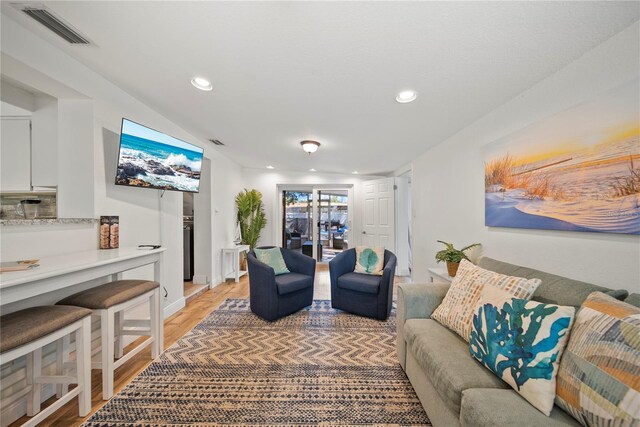 living area featuring recessed lighting, baseboards, light wood-type flooring, and visible vents