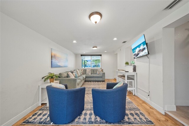 living area featuring recessed lighting, baseboards, light wood-type flooring, and visible vents