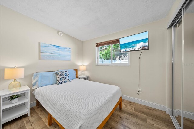 bedroom with baseboards, a closet, and wood finished floors