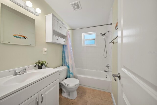 bathroom with visible vents, vanity, tile patterned floors, toilet, and shower / bath combo with shower curtain