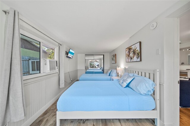bedroom with multiple windows and wood finished floors