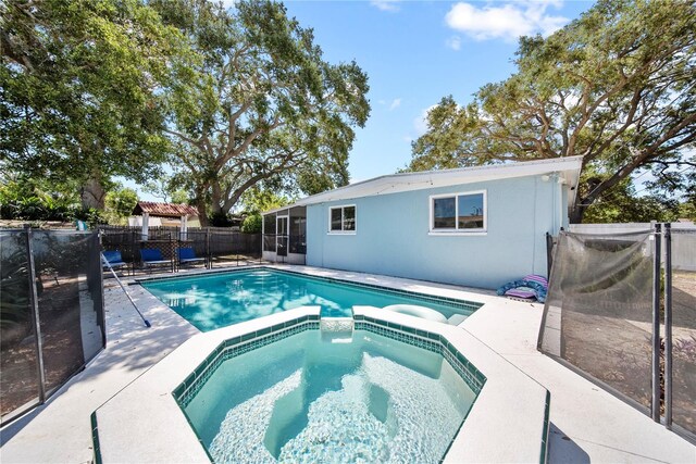view of swimming pool with fence, a patio, a sunroom, a gazebo, and a pool with connected hot tub