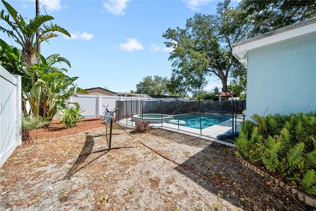 view of pool with a fenced backyard and a pool with connected hot tub