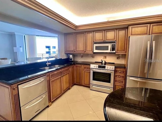 kitchen with ornamental molding, appliances with stainless steel finishes, brown cabinetry, and a sink
