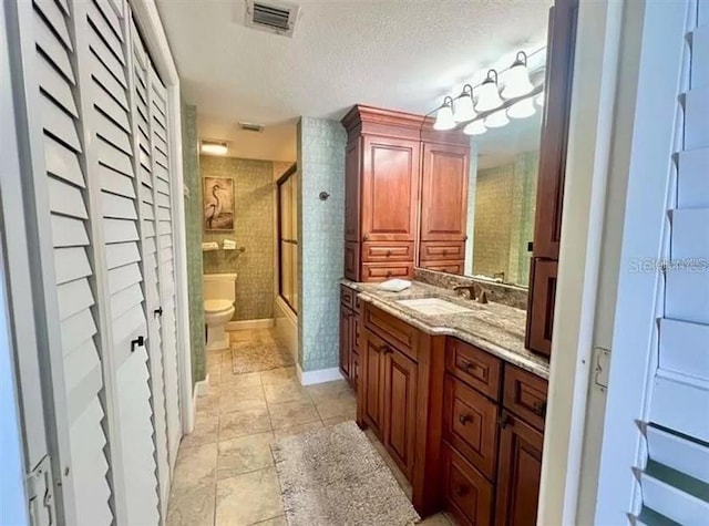 bathroom featuring visible vents, vanity, toilet, a textured ceiling, and tile patterned floors