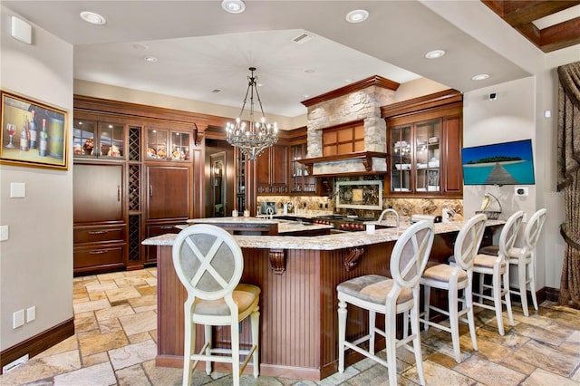1102 Merry Water Dr, Lutz, FL 33548 - kitchen featuring stone tile floors, decorative backsplash, a peninsula, baseboards, and light stone counters