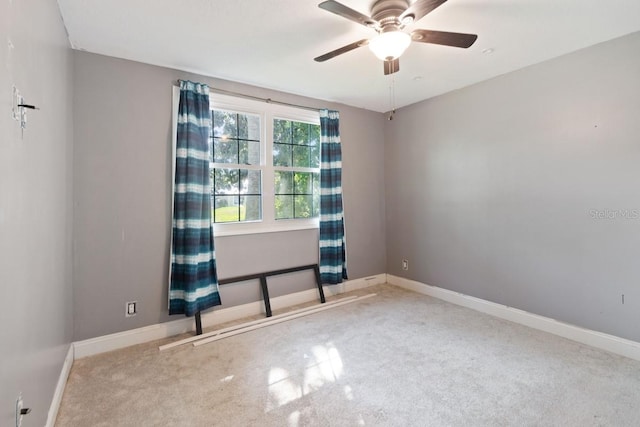 empty room with ceiling fan, carpet flooring, and baseboards