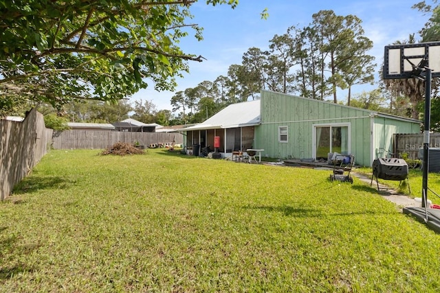 back of house featuring a fenced backyard and a lawn