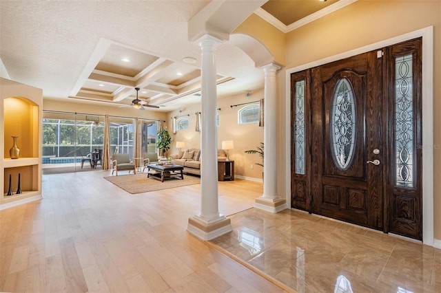 foyer entrance featuring beam ceiling, ceiling fan, decorative columns, coffered ceiling, and ornamental molding
