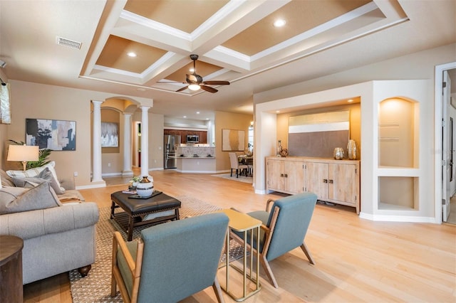 living area featuring light wood-style floors, ceiling fan, decorative columns, coffered ceiling, and visible vents