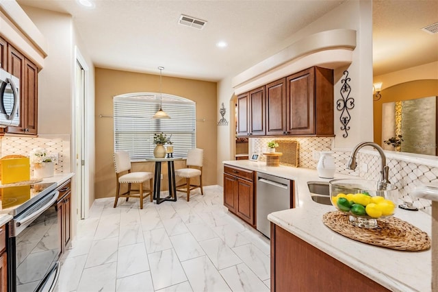 kitchen with recessed lighting, a sink, stainless steel appliances, visible vents, and light stone counters