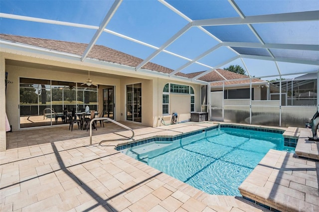 pool with a patio, a ceiling fan, and glass enclosure