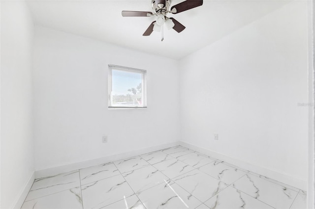 spare room with baseboards, ceiling fan, and marble finish floor