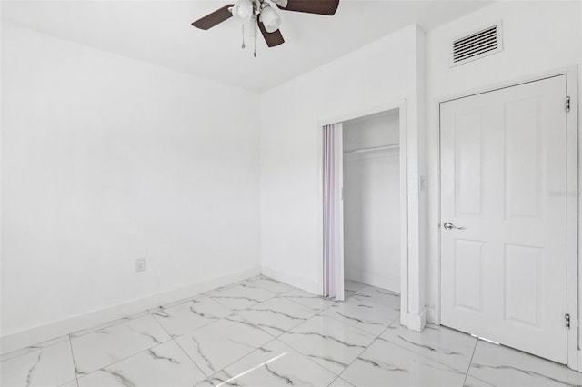unfurnished bedroom with a closet, marble finish floor, visible vents, a ceiling fan, and baseboards