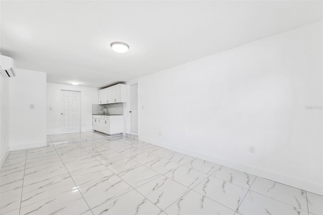 unfurnished living room with marble finish floor and baseboards