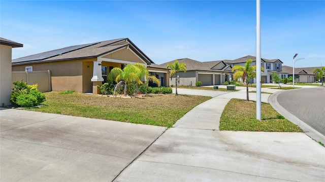 ranch-style home with a garage, a front yard, driveway, and a residential view