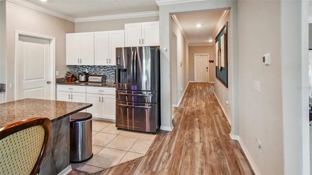 kitchen featuring light wood-type flooring, ornamental molding, white cabinetry, and stainless steel fridge with ice dispenser