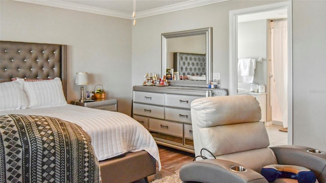bedroom featuring crown molding, wood finished floors, and ensuite bath