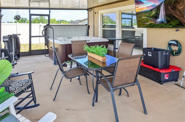 view of patio featuring a hot tub, fence, and outdoor dining space