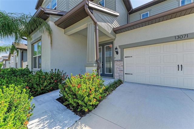 13071 Willow Grove Dr, Riverview, FL 33579 - doorway to property with an attached garage, driveway, stone siding, and stucco siding