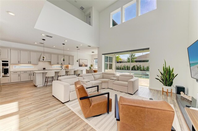 13071 Willow Grove Dr, Riverview, FL 33579 - living area featuring a towering ceiling, a wealth of natural light, and light wood-style floors