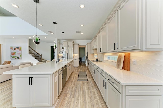 13071 Willow Grove Dr, Riverview, FL 33579 - kitchen with light wood-type flooring, a sink, open floor plan, stainless steel appliances, and recessed lighting
