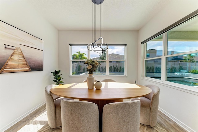 13071 Willow Grove Dr, Riverview, FL 33579 - dining area featuring light wood-style floors, baseboards, a textured ceiling, and a notable chandelier