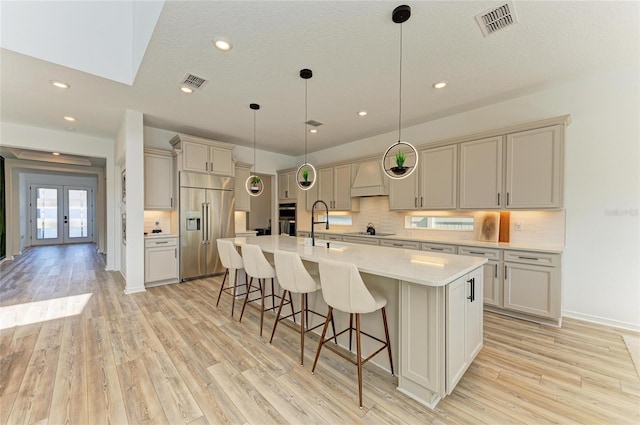 13071 Willow Grove Dr, Riverview, FL 33579 - kitchen with appliances with stainless steel finishes, a breakfast bar area, light wood-type flooring, and visible vents
