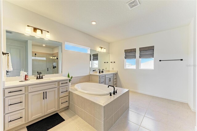 13071 Willow Grove Dr, Riverview, FL 33579 - bathroom with a sink, tile patterned floors, visible vents, a garden tub, and a stall shower