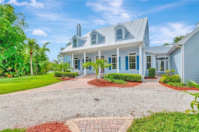16470 Oakview Cir, Alva, FL 33920 - new england style home with a chimney, metal roof, a standing seam roof, a porch, and a front lawn