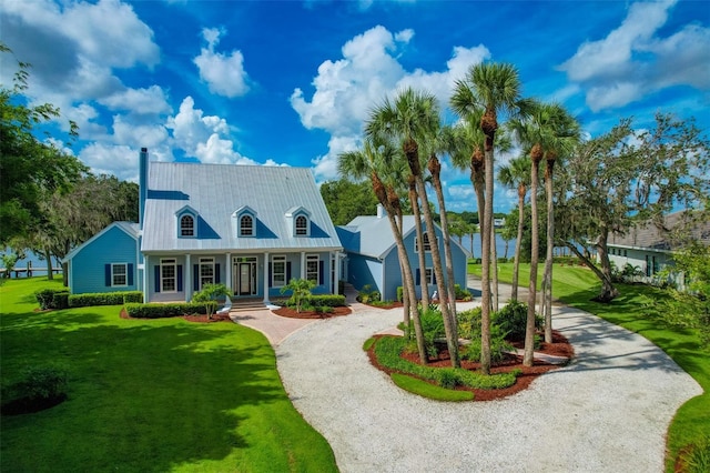 16470 Oakview Cir, Alva, FL 33920 - view of front of home featuring a porch, curved driveway, a front yard, and metal roof