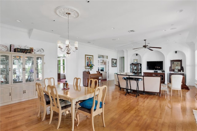 16470 Oakview Cir, Alva, FL 33920 - dining space with arched walkways, ceiling fan with notable chandelier, ornamental molding, and light wood-style flooring