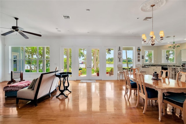 16470 Oakview Cir, Alva, FL 33920 - dining space featuring visible vents, french doors, light wood-style flooring, and ceiling fan with notable chandelier