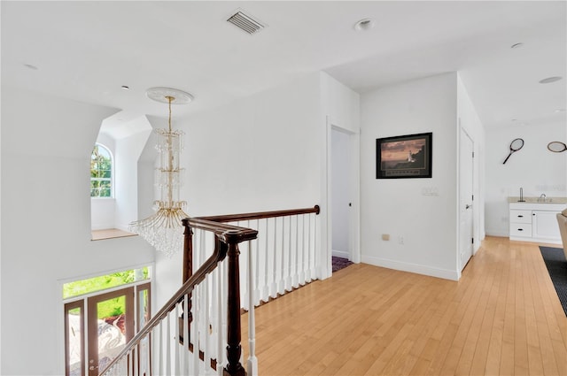 16470 Oakview Cir, Alva, FL 33920 - corridor with baseboards, visible vents, light wood-style floors, and an upstairs landing