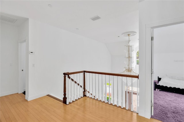16470 Oakview Cir, Alva, FL 33920 - hall featuring light wood finished floors, an inviting chandelier, an upstairs landing, visible vents, and baseboards