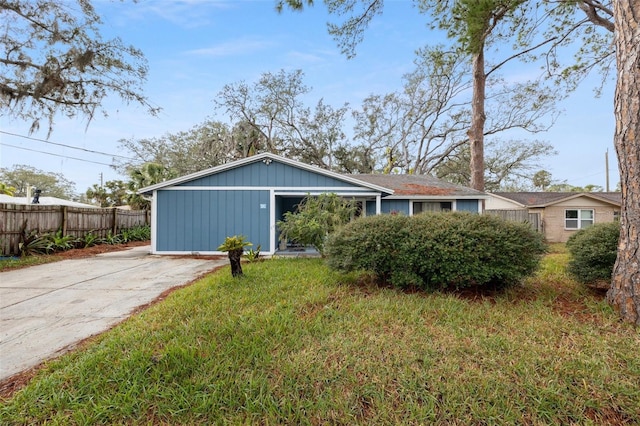 exterior space featuring board and batten siding, fence, and a front yard