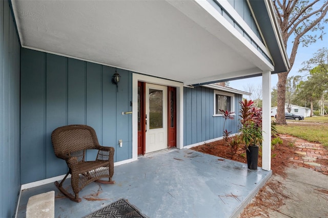 property entrance featuring board and batten siding and a patio area